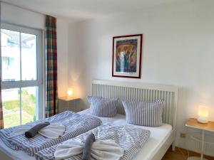 een slaapkamer met een bed met 2 kussens en een raam bij Appartementhaus Victoria - Fewo Meeresrauschen in Sassnitz