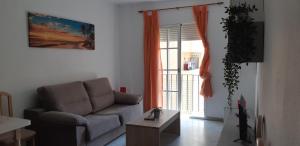 a living room with a couch and a table and a window at Apartamento Junto a El Corte Inglés Algeciras 2 in Algeciras