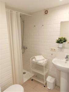 uma casa de banho com um chuveiro, um lavatório e um WC. em Apartaments Fonda Comerç em Torroella de Montgrí
