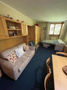 a living room with a couch and a bed at Appartamento Val di Luce in Abetone