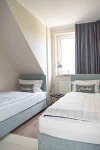 1 dormitorio con 2 camas y ventana en Schiller-Quartier 6, en Bremerhaven