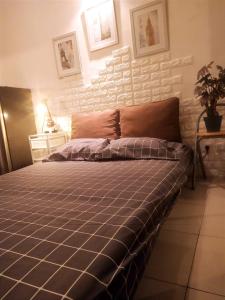 a bed in a bedroom with a brick wall at Tiny studio with pool, jogging track, gym and Mall in Jakarta
