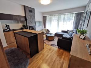 a living room with a couch and a table at Apartman Sari Bjelašnica in Bjelašnica +8 photos