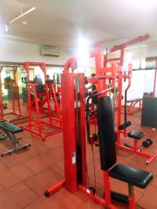 un gimnasio con equipamiento rojo en una habitación en Tiny studio with pool, jogging track, gym and Mall en Yakarta