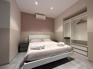 una camera da letto con un letto e due asciugamani di A Due Passi - Sanremo Apartments a Sanremo
