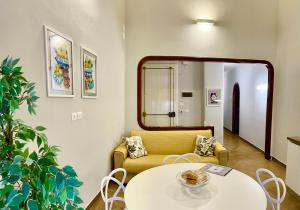 a living room with a yellow couch and a table at Sabbinirica House in Catania