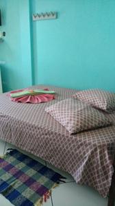 a bed with pink sheets and pillows on it at Pousada Brisas de Setiba in Guarapari