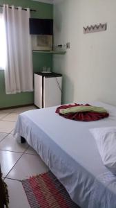 a room with two beds and a small kitchen at Pousada Brisas de Setiba in Guarapari