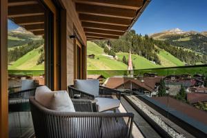 a balcony with chairs and a view of a mountain at Schönblick Appartements in Tux