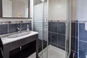 ein Bad mit einem Waschbecken und einer Dusche in der Unterkunft Will's Hotel in Narbonne