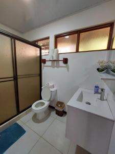 a bathroom with a toilet and a sink at Hôtel Pez Gallo in Golfito