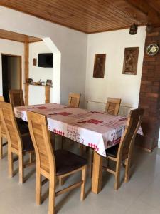 einen Esstisch mit Stühlen, einem Tisch und einer Tischdecke in der Unterkunft Pensiunea Lucica in Vişeu de Jos