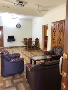 Sala de estar con 2 sofás y mesa en ASP COTTAGE, en Tenkāsi