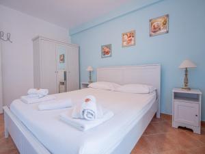 Un dormitorio con una cama blanca con toallas. en Sogno Greco, en Elafonisos