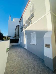 un bâtiment blanc avec un panneau sur son côté dans l'établissement Lisbon Ocean Apartments, à Costa da Caparica
