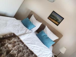 a bedroom with a white bed with blue pillows at Komfort Appartement Panoramaweg in Waldenbuch