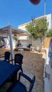 un patio con mesa y sillas bajo un pabellón en Sogno Greco, en Elafonisos