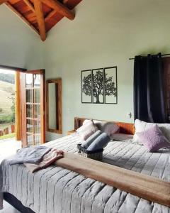 Un dormitorio con una cama grande y una ventana en Chalés e Bangalôs Capim Limão en Bueno Brandão