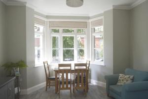 a dining room with a table and chairs and windows at Victoria Lodge Woodhall Spa in Woodhall Spa