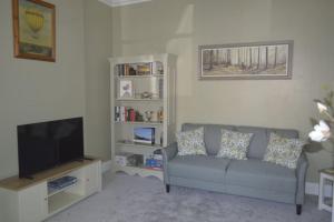 a living room with a couch and a flat screen tv at Victoria Lodge Woodhall Spa in Woodhall Spa
