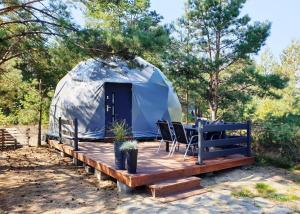 a yurt with a table and chairs on a wooden deck at Podniebny Glamping in Borsk