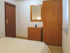 a bedroom with a bed and a dresser and a mirror at Apartments Janči, Murter (Croatia) in Murter