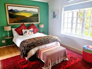 a bedroom with a bed and a painting on the wall at Art House in Stellenbosch