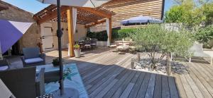 a wooden deck with a table and an umbrella at L'AUTHENTIQUE in Eurre