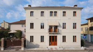una casa blanca con puertas rojas y una valla en VILLA MARGHERITA, en Pieve di Soligo