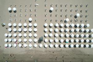 - une vue aérienne sur un parking avec des parasols dans l'établissement Fllad Resort & SPA Durres, à Golem