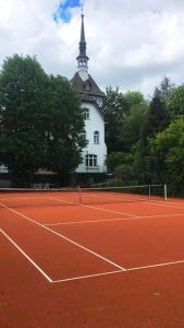a tennis court with a building in the background at Luxus Villa EMG Dortmund nah Düsseldorf, Köln, Essen in Ennepetal