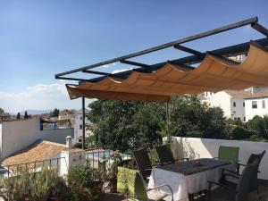 eine Terrasse mit einem Sonnenschirm, einem Tisch und Stühlen in der Unterkunft Estudio con vistas Albayzin in Granada