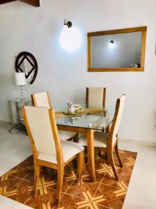 comedor con mesa de cristal y sillas en Casa 39-37, en Cartagena de Indias