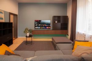 ein Wohnzimmer mit einem Sofa und einem Flachbild-TV in der Unterkunft Borghetto First in Piacenza