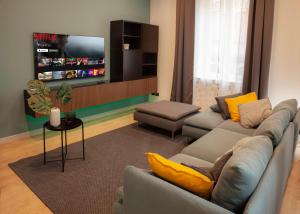 a living room with a couch and a tv at Borghetto First in Piacenza