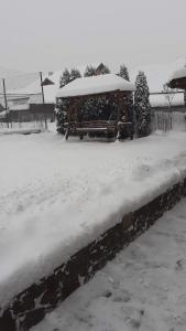 einen schneebedeckten Hof mit einem Pavillon in der Unterkunft Pensiunea Lucica in Vişeu de Jos