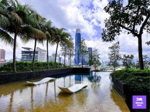 duas cadeiras brancas numa piscina de água com palmeiras em Continew Residences TRX Lux Pool View em Kuala Lumpur