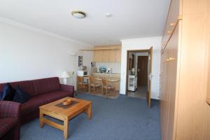 a living room with a red couch and a table at Haus Norderhoog Wohnung 39 in Westerland