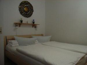 ein Bett mit weißer Bettwäsche und Kissen in einem Schlafzimmer in der Unterkunft Haus Norderhoog Wohnung 56 in Westerland
