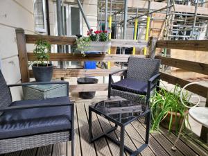 a balcony with two chairs and a table and plants at Three Bedroom Apartment by Beautiful Park in London