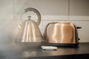a tea kettle on a counter next to a toaster at Liverpool At Gloucester Road - Infinity Apartments in Liverpool