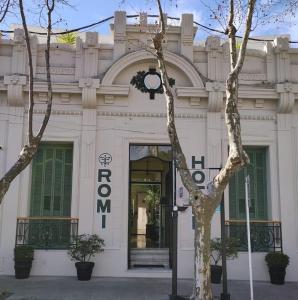 un edificio blanco con un cartel en la parte delantera en Hotel Romi en Colonia del Sacramento