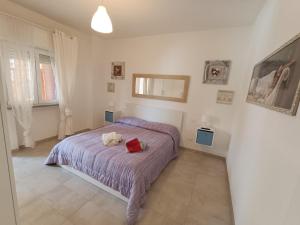 ein Schlafzimmer mit einem Bett mit einer roten Tasche darauf in der Unterkunft Il Don Minzoni 98 "Casa Vacanze" in Lido di Camaiore