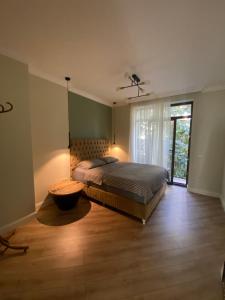 a bedroom with a bed and a large window at Classic and New brand Apartment San Stefano 9 in Varna City