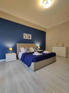 a bedroom with a bed and a blue wall at Elpida Apartment Reggio Calabria in Reggio di Calabria
