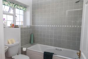 un bagno con una vasca bianca e un water di Monks Cleeve Bungalow a Exford Altre 6 foto