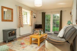 a living room with a couch and a fireplace at Monks Cleeve Bungalow in Exford
