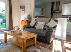 un soggiorno con divano e tavolo di Monks Cleeve Bungalow a Exford