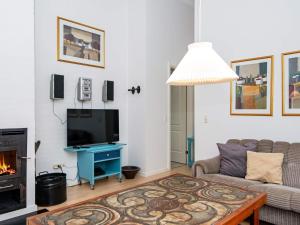 a living room with a couch and a tv and a fireplace at 8 person holiday home in Aabenraa-By Traum in Løjt