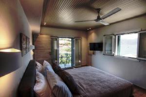 1 dormitorio con 1 cama y ventilador de techo en Fiskardo Beach House, en Fiskardho